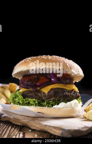 Big Burger frais sur fond de bois rustique (avec frites) Banque D'Images