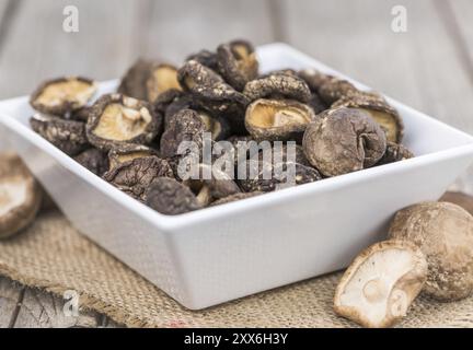 Champignons Shiitake frais (séchés) sur une table en bois ancienne et rustique, mise au point sélective, gros plan Banque D'Images