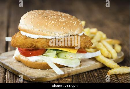 Hamburger de poisson maison (gros plan, mise au point sélective) sur une table en bois Banque D'Images