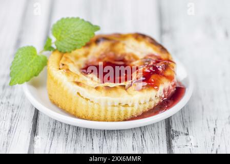 Mini Cheesecake frais (avec la sauce) sur un arrière-plan vintage (gros plan) Banque D'Images