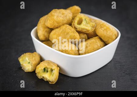 Quelques Piments Nuggets de fromage sur une dalle d'ardoise vintage (selective focus) Banque D'Images