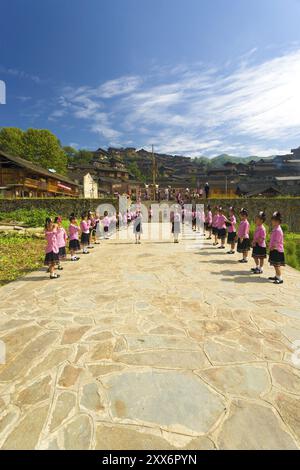 Xijiang, Chine, 15 septembre 2007 : de mignonnes adolescentes se préparent pour la cérémonie du festival dans des vêtements roses traditionnels sur la place de la ville de Beautiful et Banque D'Images