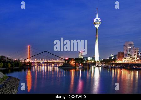 Ambiance nocturne dans le port des médias avec pont de genou du Rhin, tour du Rhin et maisons Gehry, Duesseldorf, Rhénanie, Rhénanie du Nord-Westphalie, Allemagne Banque D'Images