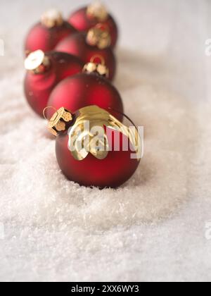 Ancien vintage rouge boules de Noël dans une rangée sur la neige, fond de carte de Noël Banque D'Images