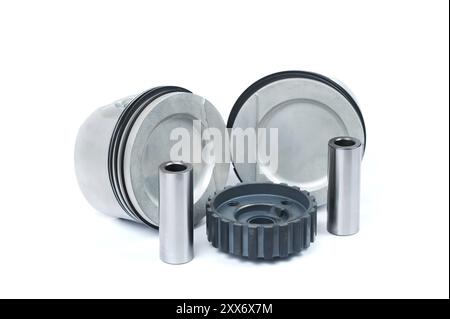 Gros plan des pièces de rechange deux nouveaux pistons avec bielles pour un moteur à essence avec jeux de segments de piston installés et pignon de vilebrequin sur un i. Banque D'Images