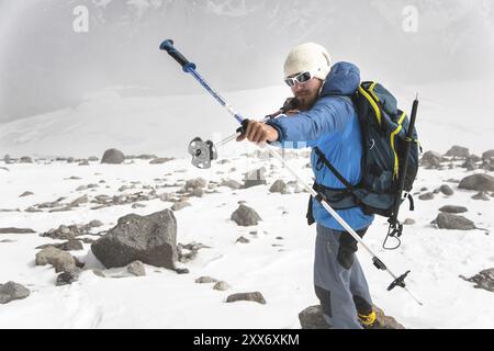 Backpacker dans les montagnes prétend qu'il tire un arc en utilisant l'exemple des bâtons pour la marche scandinave dans le contexte d'un St imminent Banque D'Images