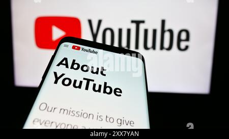 Téléphone mobile avec le site Web de la société YouTube de plate-forme de partage de vidéos en ligne américaine devant le logo de l'entreprise. Concentrez-vous sur le coin supérieur gauche de l'écran du téléphone. Banque D'Images