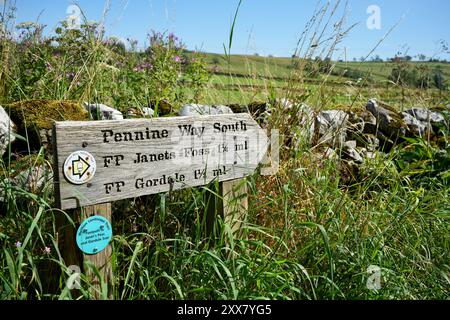 Joli panneau en bois sur le Pennine Way avec des collines derrière. Banque D'Images