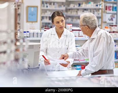 Pharmacien, homme âgé et document au comptoir pour consultation, prescription de médicaments et conseils de santé. Femme, client et paperasse pour Banque D'Images