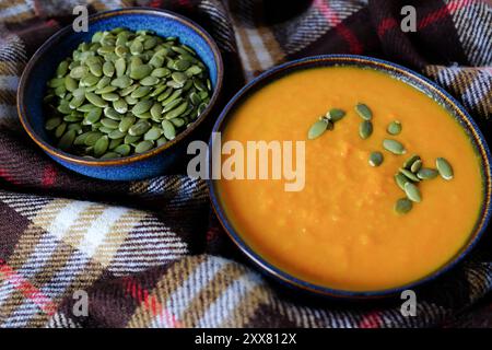 Soupe de carottes au gingembre avec graines de citrouille dans Blue Bowl Banque D'Images