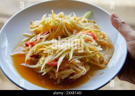 Salade de papaye verte épicée ou nourriture thaïlandaise Som Tum servie dans l'assiette Banque D'Images