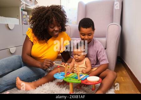 Famille heureuse jouant de la musique avec xylophone à la maison Banque D'Images