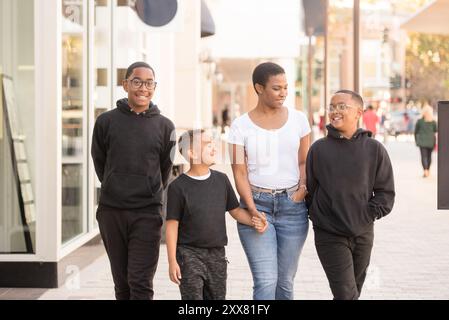 Mère marchant au centre-ville avec ses fils Banque D'Images