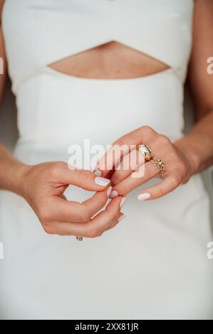 Image verticale de la femme dans la robe blanche moderne- Focus sur les mains Banque D'Images