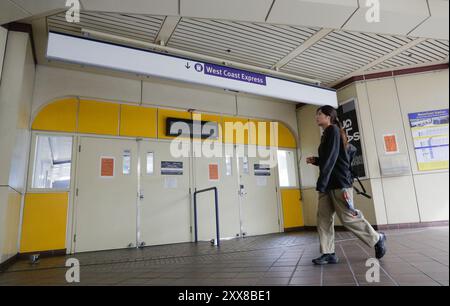 Vancouver, Canada. 22 août 2024. Une femme passe devant l'entrée fermée de la station West Coast Express au centre-ville de Vancouver, Colombie-Britannique, Canada, 22 août 2024. Les trains à travers le Canada ont été interrompus jeudi en raison de la grève de 9 300 travailleurs des deux principales compagnies ferroviaires du pays, le chemin de fer canadien National (CN Rail) et le canadien Pacifique Kansas City (CPKC). Crédit : Liang Sen/Xinhua/Alamy Live News Banque D'Images