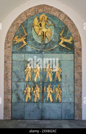 Suisse, canton du Valais, Saint Maurice, abbaye Saint Maurice d'Agaune, porte lourde à l'entrée, à l'extérieur, le plasticien français Philippe Kaeppelin représentait le Christ de l'Ascension et huit soldats thébains Banque D'Images