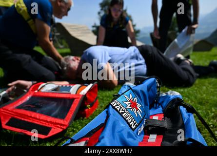 Oberaudorf, Allemagne. 23 août 2024. Les membres du service de sauvetage en montagne bavarois démontrent comment traiter un randonneur souffrant de problèmes cardiovasculaires lors d'une conférence de presse à l'auberge de montagne Hocheck. Le sujet est les dangers du changement climatique dans les sports de montagne et les problèmes cardiovasculaires comme cause la plus fréquente d'accidents en montagne. Crédit : Sven Hoppe/dpa/Alamy Live News Banque D'Images