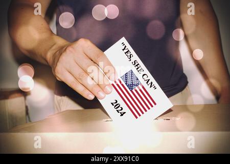 Kamala Harris nouveau slogan 'Yes, she CAN'. Elections USA. 2024. Hand dépose son vote dans les urnes. Drapeaux américains en arrière-plan, dos flou Banque D'Images