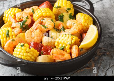 Faites maison Cajun Seafood bouillir avec des crevettes, du maïs, des pommes de terre, des saucisses et des citrons en gros plan sur la table. Horizontal Banque D'Images