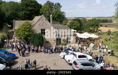 Les gens font la queue dehors à l'ouverture du nouveau pub de Jeremy Clarkson, The Farmer's Dog, à Asthall, près de Burford dans l'Oxfordshire. Date de la photo : vendredi 23 août 2024. Banque D'Images