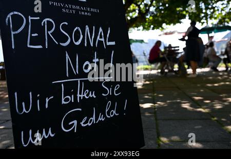 Oberaudorf, Allemagne. 23 août 2024. Un panneau avec l'inscription 'Personal Not! - Nous demandons votre patience!' a l'entrée d'un jardin de bière. Crédit : Sven Hoppe/dpa/Alamy Live News Banque D'Images