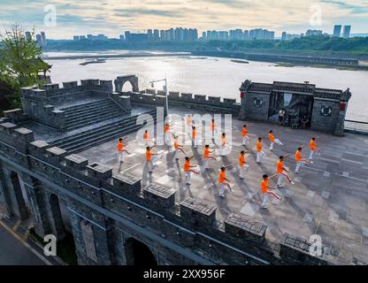 Guang'an. 21 août 2024. Une photo de drone aérien prise le 21 août 2024 montre des citoyens faisant des exercices matinaux sur le mur de la porte nord de la route de Binjiang dans le district de Guang'an de la ville de Guang'an, dans la province du Sichuan au sud-ouest de la Chine. La ville de Guang'an, située dans la partie orientale du bassin du Sichuan, est la ville natale de Deng Xiaoping. Avec de beaux paysages et une culture riche, Guang'an a profité pour stimuler la construction d'infrastructures et le développement industriel de la ville pendant le processus de construction du cercle économique Chengdu-Chongqing. Crédit : Zhang Guosheng/Xinhua/Alamy Live News Banque D'Images