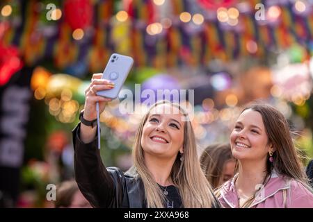 (de gauche à droite) les mankuniens Devon et Lucy posent pour un selfie sur canal Street dans le quartier Gay de Manchesters alors que la tempête Lilian ne parvient pas à entraver le début de la fierté de Manchester pour les arrivées anticipées. Manchester Pride 2024 . Le thème de cette année est "Buzzin to be Queer - A Hive of Progress" et les organisateurs disent qu'ils espèrent qu'il "unira le peuple de Manchester" sous le symbole de l'abeille de Manchester. En vedette de Jessie J, Loreen, Sugababes, Rita Ora et de la plus grande star de Showman Keala Settle. La première Pride Parade de Manchester a eu lieu le 20 février 1988, quand une énorme manifestation anti-section 28 a eu lieu dans l'ic Banque D'Images