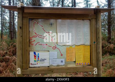 Panneau d'information touristique à El Bosque de Oma, une forêt avec des arbres peints et du Land art près de Kortezubi dans le pays Basque, Espagne Banque D'Images