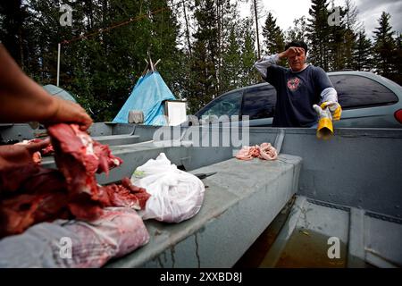 La bande des Chipewyans de Première nation qui vit dans la région de Fort McKay s'inquiètent de l'impact environnemental de ce qui permet à l'huile pour l'exploitation d'entreprises de sable dans leur quartier. LeCorde twoheaded Dennis parle de poissons dans la rivière Athabasca. Son frère Howard LeCorde viande coupes d'un orignal fraîchement tués. Banque D'Images