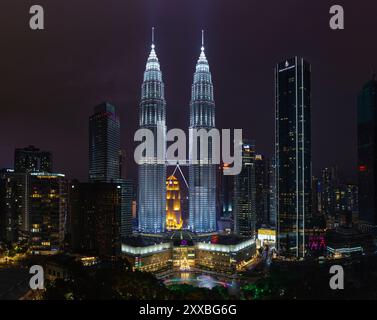 Une photo des tours jumelles Petronas, du spectacle des fontaines d'eau et de lumière du parc KLCC et du centre commercial Suria KLCC la nuit. Banque D'Images