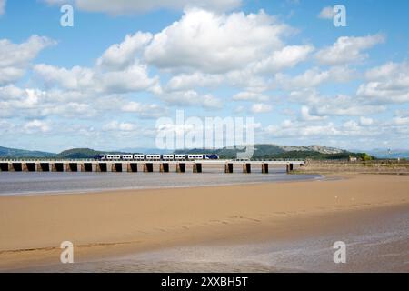 Un train de voyageurs traverse le viaduc ferroviaire Kent, Arnside, Cumbria. Banque D'Images