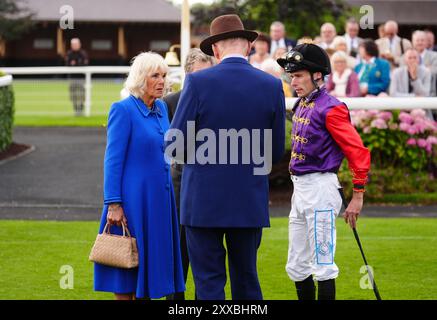 La reine Camilla avec l'entraîneur John Gosden et le jockey Kieran Shoemark pendant la troisième journée du Sky Bet Ebor Festival à l'hippodrome de York. Date de la photo : vendredi 23 août 2024. Banque D'Images