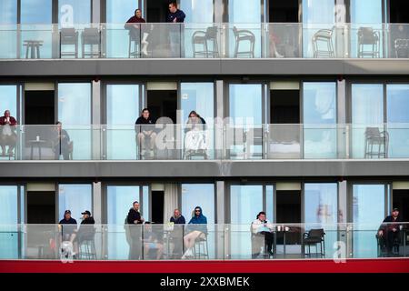 Les clients du Hilton Garden Inn regardent le match depuis leur balcon pendant la troisième journée du premier Rothesay test match à l'Emirates Old Trafford, Manchester. Date de la photo : vendredi 23 août 2024. Banque D'Images