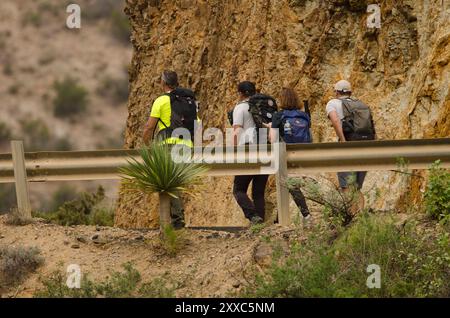 Barrage de la Encantadora, 9 décembre 2023 : randonneurs marchant le long d'une route. Vallehermoso. La Gomera. Îles Canaries. Espagne. Banque D'Images