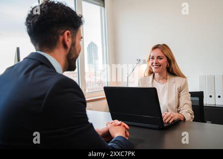 Une femme responsable des ressources humaines mène un entretien d'embauche avec un nouvel employé. Une vendeuse, un directeur financier ou un courtier en valeurs mobilières discutant et rencontrant un client dans son bureau. Photo de haute qualité Banque D'Images