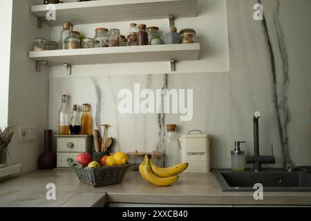 Panier avec des fruits frais sur la table dans la cuisine, bananes sur le préjugé Banque D'Images