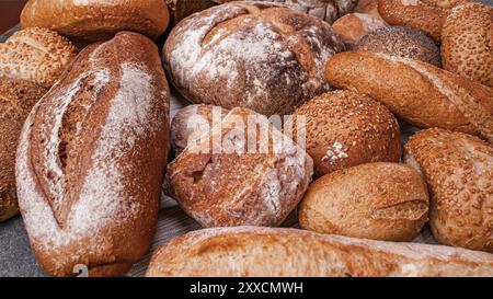 Variété de pain au levain cuit sur pain de table en bois de pain artisanal. Pain frais parfumé sur la table. Concept alimentaire . Différents types de pain. Banque D'Images