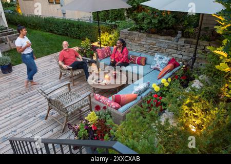 Une famille traînant sur leur terrasse un soir d'été Banque D'Images