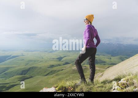 Une fille de taille basse dans un chapeau de paille et des verres sur le paysage de la nature Banque D'Images