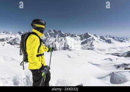 Portrait d'un skieur freerider professionnel debout sur une pente enneigée sur fond de montagnes enneigées. Le concept des sports d'hiver Banque D'Images