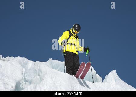 Un skieur freerider en tenue complète se dresse sur un glacier dans le Nord Caucase. Le skieur se prépare avant de sauter du glacier Banque D'Images