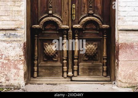 Fond vintage. Eléments d'une ancienne porte en bois sculpté décorée de volumineux éléments en bois sculpté imitant le tissage. Un concept vintage de Banque D'Images