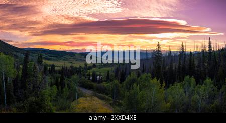 Un lever de soleil vibrant sur les montagnes à l'extérieur de Steamboat Springs, CO. Beaucoup de couleurs chaudes dans le ciel avec beaucoup de vert au premier plan. ouest des États-Unis Banque D'Images