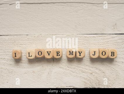 Dés en bois avec les mots J'aime mon travail sur une table en bois blanc Banque D'Images