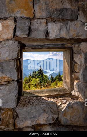 Vue sur le lac Zaovine depuis un vieux cadre de fenêtre sur un mur de pierre brute sur la montagne Tara en Serbie. Banque D'Images