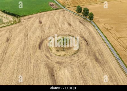 Une route passe devant un ancien monticule funéraire dans la campagne de Skamby sur l'île de Funen, au Danemark Banque D'Images