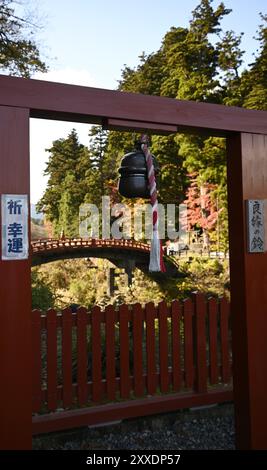 Vue panoramique d'une ancienne porte Shinto Torii en bois laqué vermillon à l'entrée du pont Shinkyō, traversée d'une rivière sacrée à Nikkō, Japon. Banque D'Images