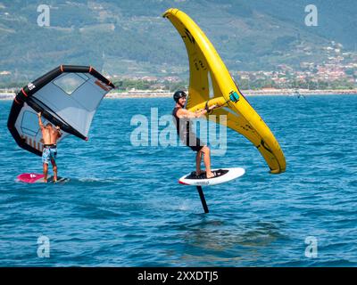 Fiumaretta di Ameglia, Italie - 22 août 2024 : L'homme pratique le fleuret dans la mer ligure. Wing foil est un sport nautique dynamique combinant le surf et le K. Banque D'Images