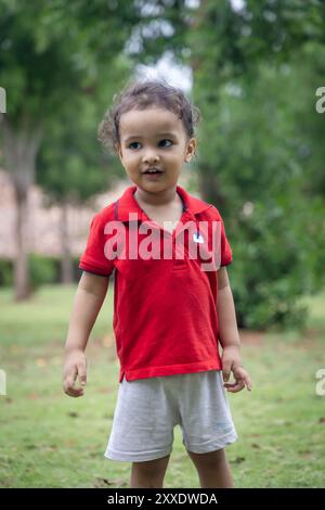 enfant indien isolé marchant au parc extérieur le soir à partir d'un angle plat Banque D'Images