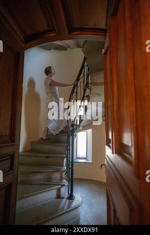 Une femme se tient debout sur un escalier en colimaçon Banque D'Images